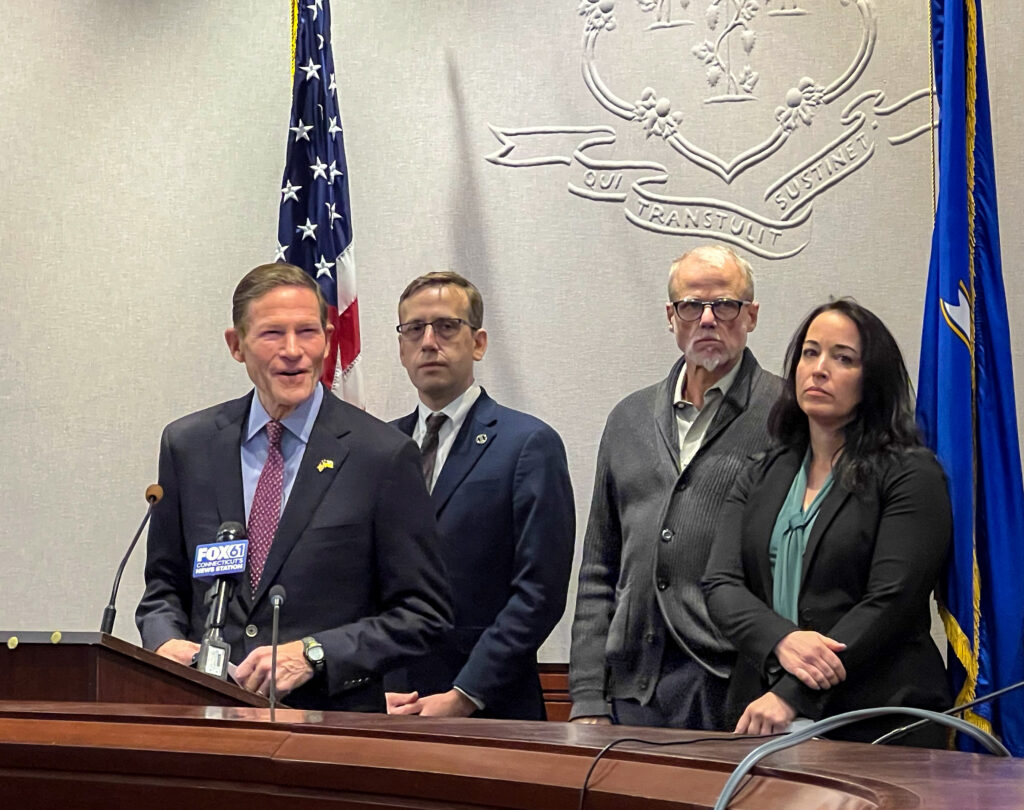 Sen. Richard Blumenthal, Rep. Matt Lesser, Mercy participant Chris, and Sarah Fox at podium
